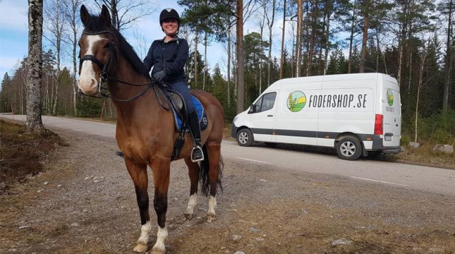 Ellen på sin egen häst. I bakgrunden syns bussen som levererar foder inom cirka 10 mils radie.
