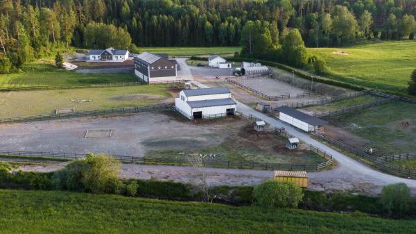 Modern hästgård med boende, stall och ridbana