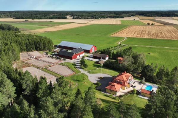 Hästgård med två bostadshus, ridhus och 42 hektar mark